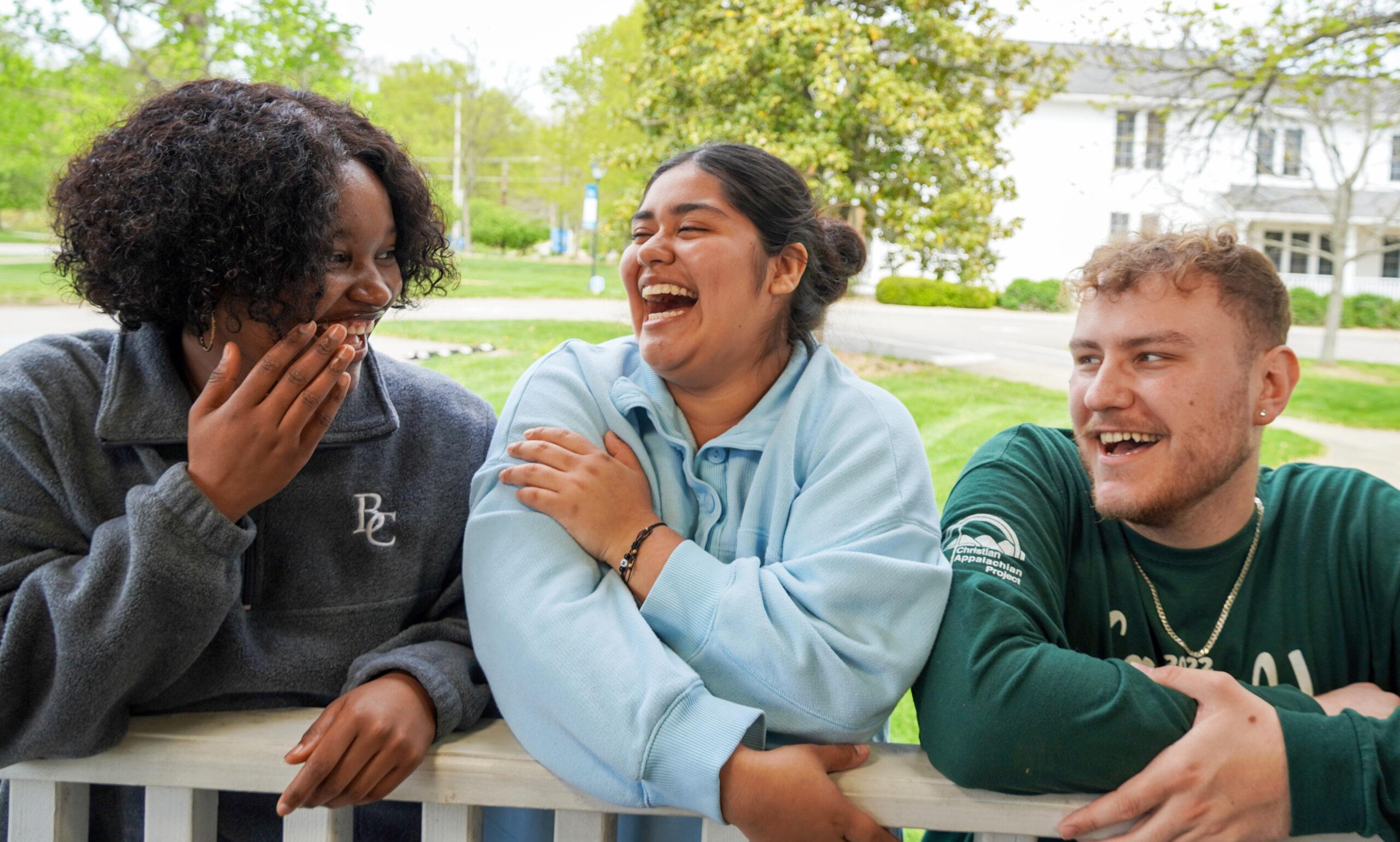 Students laughing together in front of Haaga House.